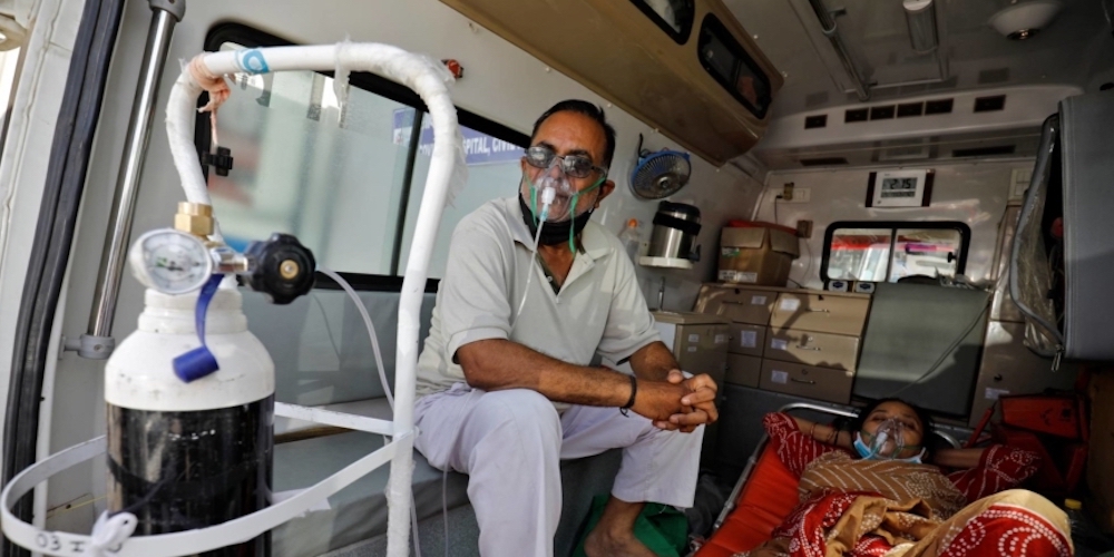 Patients with breathing problem wait inside an ambulance to enter a COVID-19 hospital for treatment, in Ahmedabad