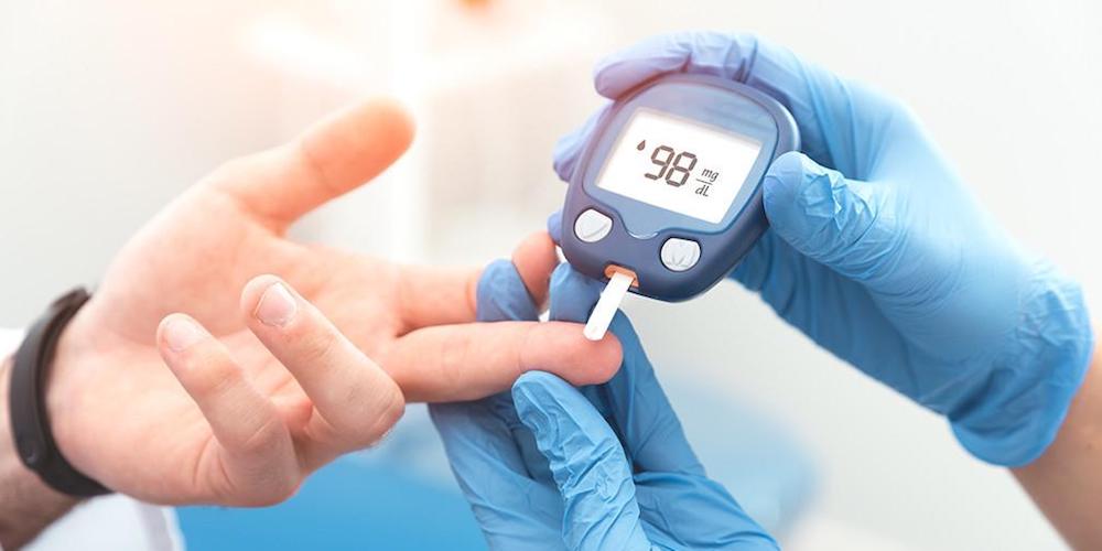 Doctor checking blood sugar level with glucometer
